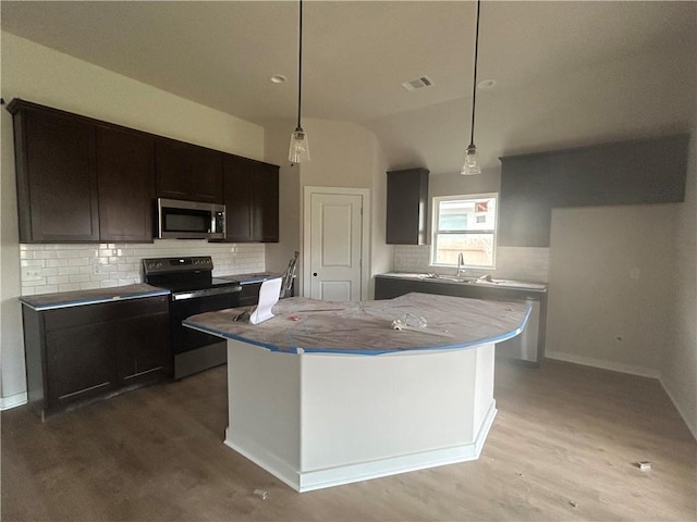 1935 Pinemont View Dr, Bryan, TX 77807 - kitchen featuring black / electric stove, stainless steel microwave, wood finished floors, and decorative backsplash