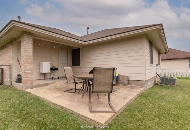 back of house featuring central air condition unit, a patio area, and a lawn