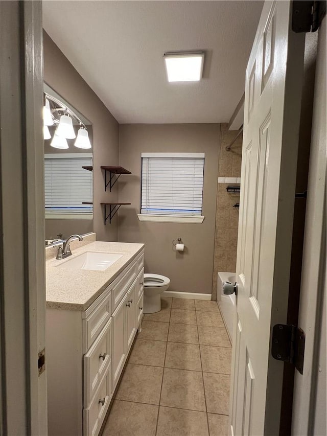 full bathroom featuring tile patterned floors, tiled shower / bath, vanity, and toilet