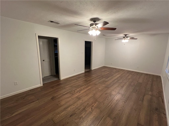 unfurnished bedroom featuring ceiling fan, dark wood-type flooring, and a textured ceiling