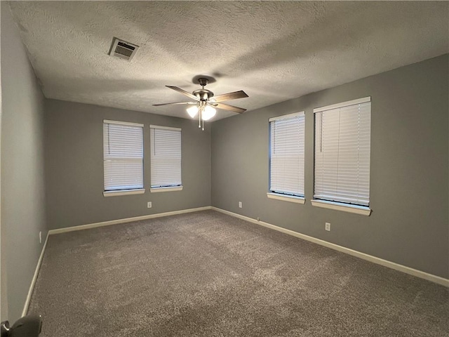 spare room with carpet flooring, ceiling fan, and a textured ceiling