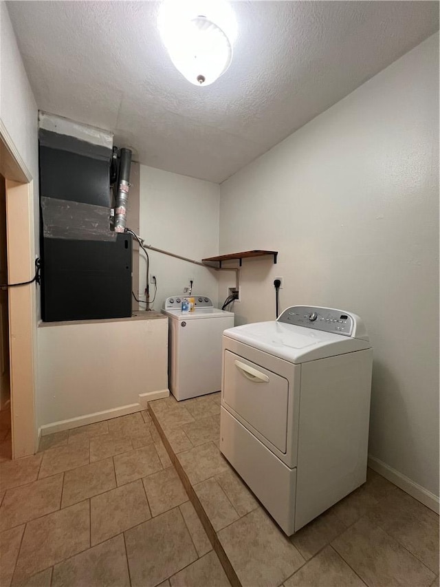 washroom with washing machine and dryer, a textured ceiling, and heating unit