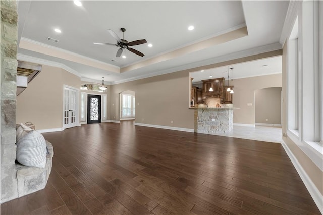4018 Arboleda Dr, College Station, TX 77845 - unfurnished living room featuring arched walkways, a raised ceiling, dark wood-style floors, ceiling fan, and crown molding
