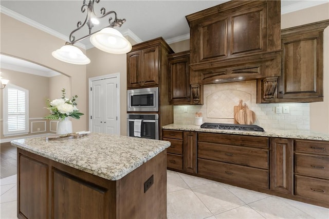 4018 Arboleda Dr, College Station, TX 77845 - kitchen with appliances with stainless steel finishes, crown molding, decorative backsplash, and light stone countertops