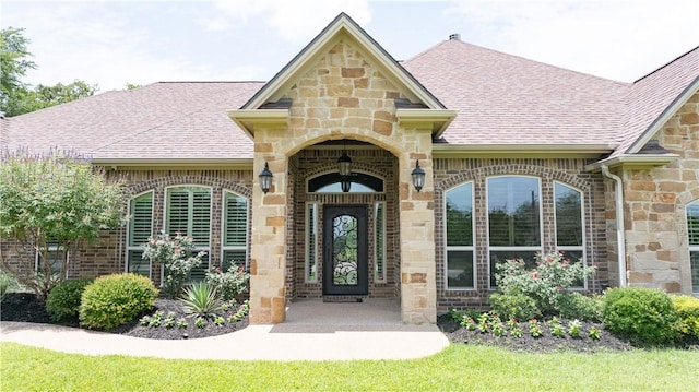 4018 Arboleda Dr, College Station, TX 77845 - property entrance featuring roof with shingles, stone siding, and brick siding