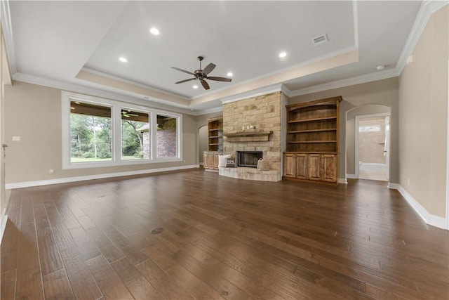 4018 Arboleda Dr, College Station, TX 77845 - unfurnished living room featuring a raised ceiling, arched walkways, ceiling fan, dark wood-type flooring, and crown molding