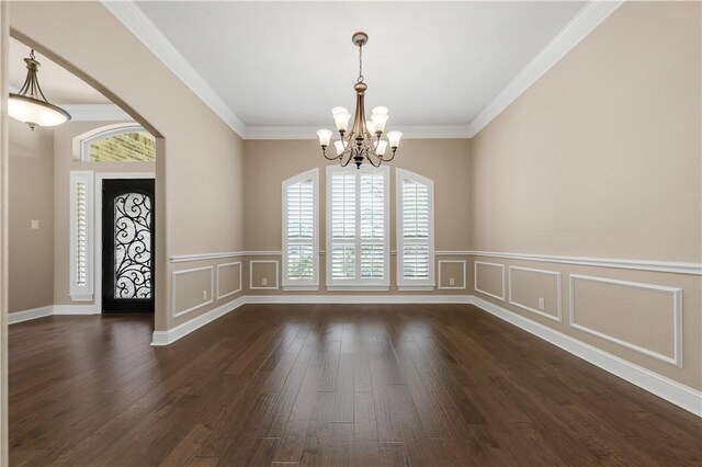 4018 Arboleda Dr, College Station, TX 77845 - unfurnished dining area featuring a chandelier, a decorative wall, dark wood finished floors, ornamental molding, and wainscoting