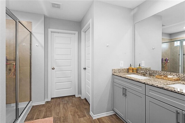 1147 Buffalograss Trl, Sealy, TX 77474 - full bathroom with a shower stall, wood finished floors, double vanity, and baseboards