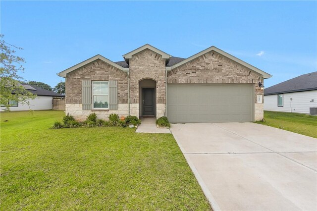 1147 Buffalograss Trl, Sealy, TX 77474 - view of front of property with an attached garage, a front lawn, concrete driveway, and cooling unit