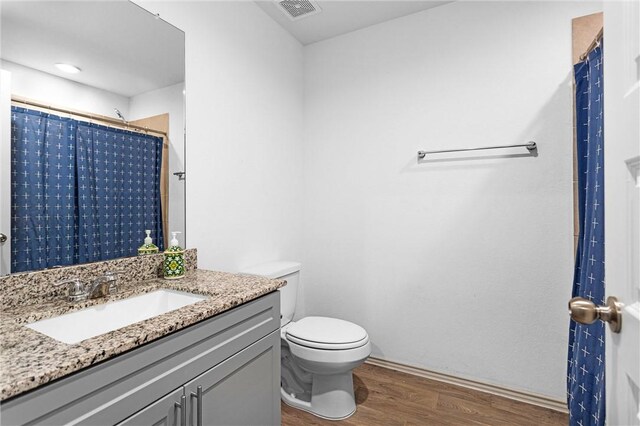 1147 Buffalograss Trl, Sealy, TX 77474 - bathroom with wood finished floors, toilet, vanity, baseboards, and a shower with curtain