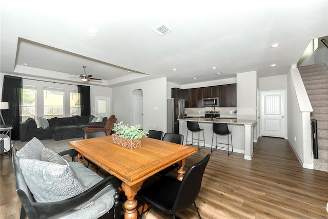 5759 Cerrillos Dr, Bryan, TX 77807 - dining room featuring a tray ceiling, a ceiling fan, wood finished floors, stairs, and recessed lighting
