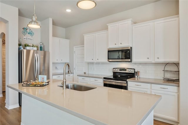 kitchen with appliances with stainless steel finishes, sink, and white cabinets