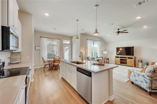 kitchen featuring white cabinetry, appliances with stainless steel finishes, a kitchen island with sink, and sink