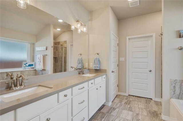 bathroom with vanity, shower with separate bathtub, and vaulted ceiling