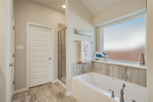 bathroom featuring shower with separate bathtub