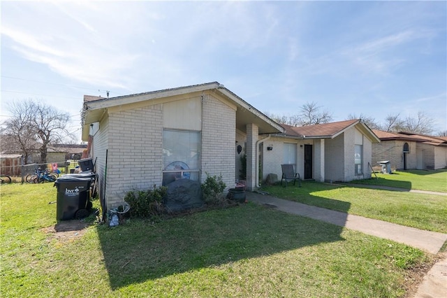 view of front of property featuring a front lawn and brick siding