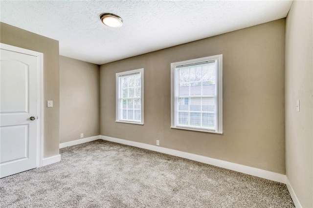 empty room with baseboards, carpet flooring, and a textured ceiling