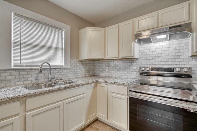 kitchen featuring backsplash, stainless steel electric range oven, a sink, and under cabinet range hood