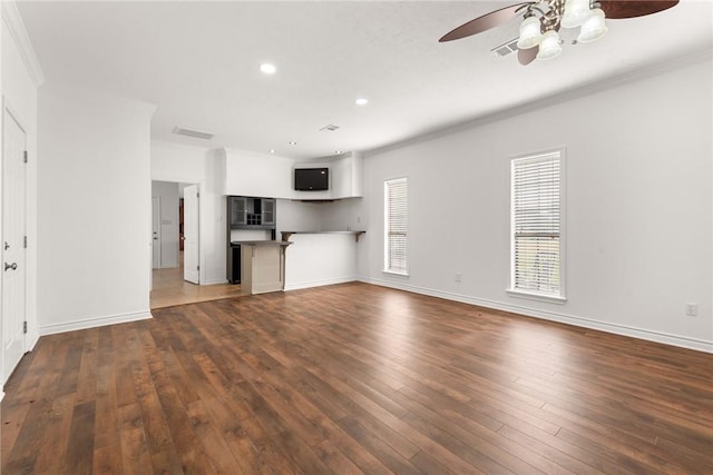 unfurnished living room with crown molding, ceiling fan, and dark wood-type flooring