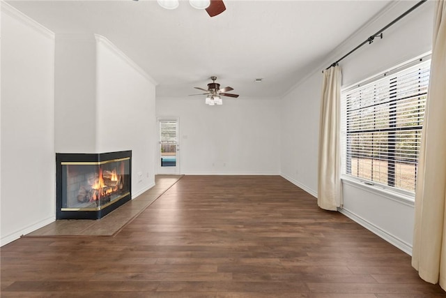 unfurnished living room featuring dark hardwood / wood-style floors, ceiling fan, a multi sided fireplace, and ornamental molding