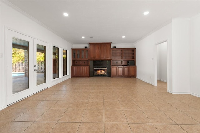 unfurnished living room featuring light tile patterned floors, crown molding, and french doors