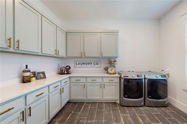 laundry room featuring washer and dryer, dark wood-type flooring, and cabinets