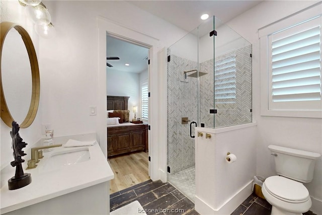 bathroom featuring ceiling fan, toilet, vanity, a shower with shower door, and hardwood / wood-style flooring