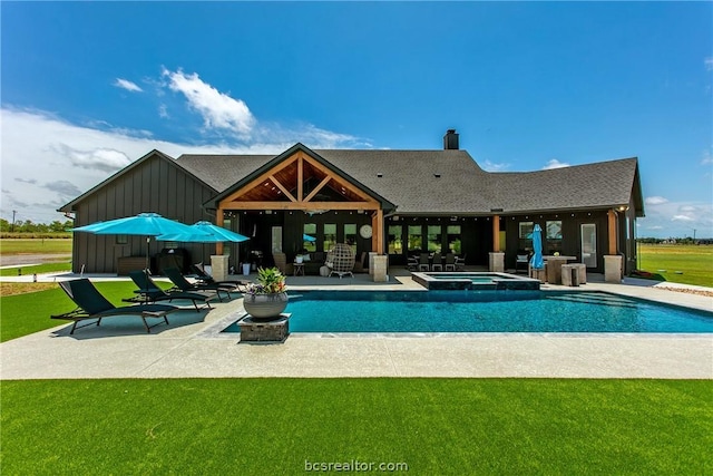 view of swimming pool with an in ground hot tub, a patio, and a lawn