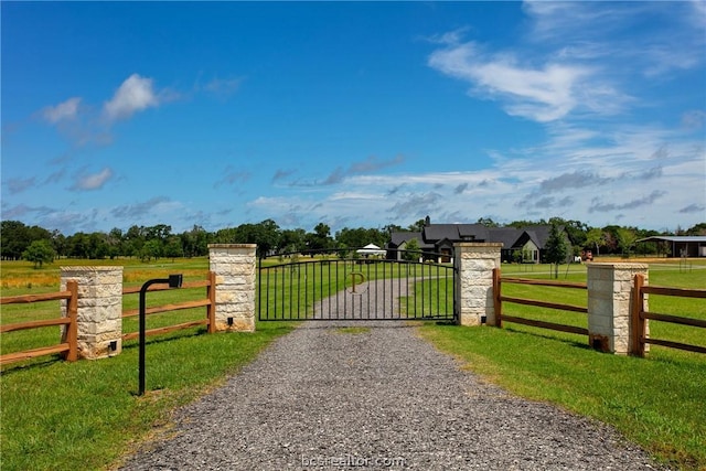 view of gate featuring a yard and a rural view