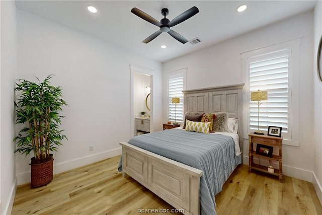 bedroom featuring light wood-type flooring, ensuite bathroom, and ceiling fan