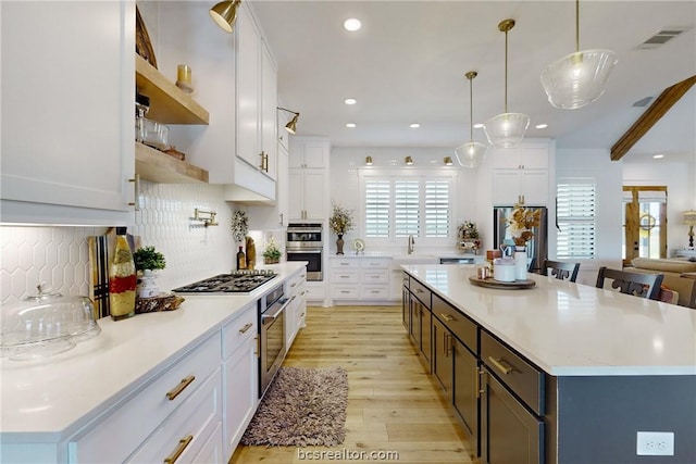 kitchen with pendant lighting, white cabinets, and a healthy amount of sunlight