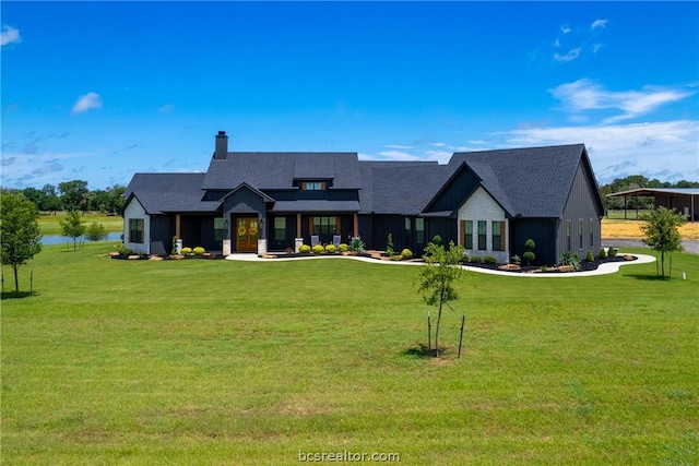 view of front of house with a water view and a front lawn