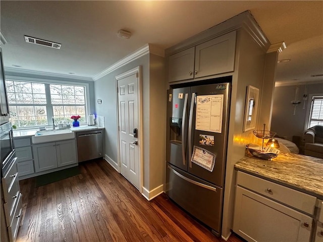 306 Timber St, College Station, TX 77840 - kitchen featuring stainless steel appliances, a sink, ornamental molding, dark wood-style floors, and baseboards