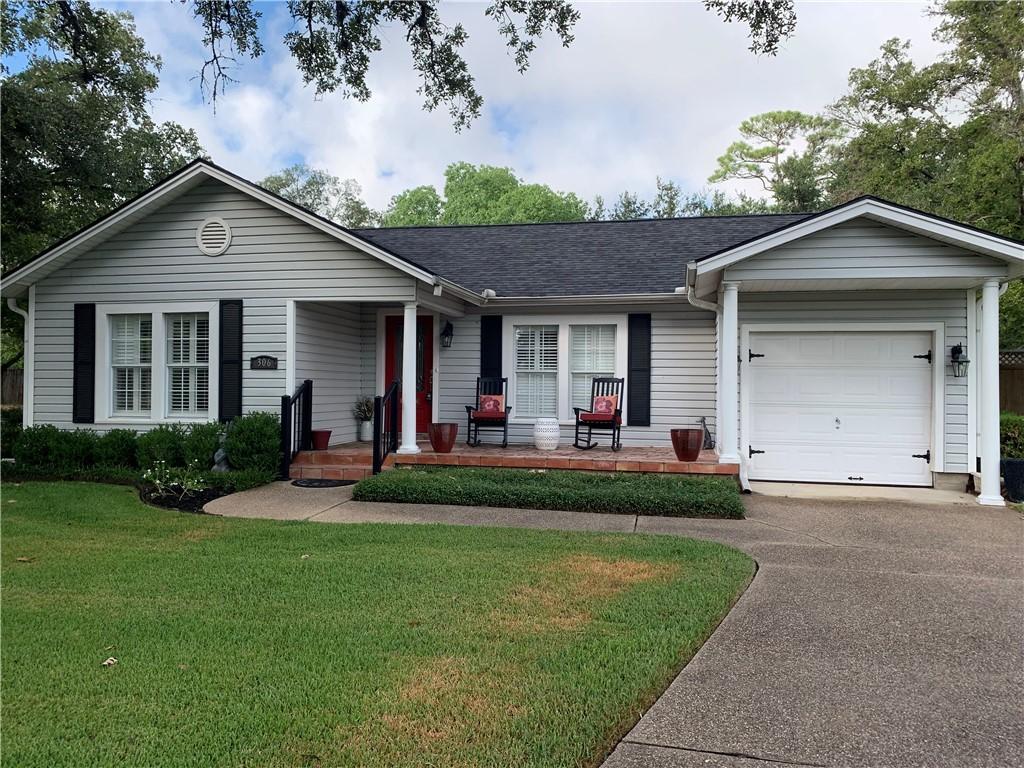 306 Timber St, College Station, TX 77840 - single story home featuring a porch, an attached garage, a front yard, driveway, and a shingled roof