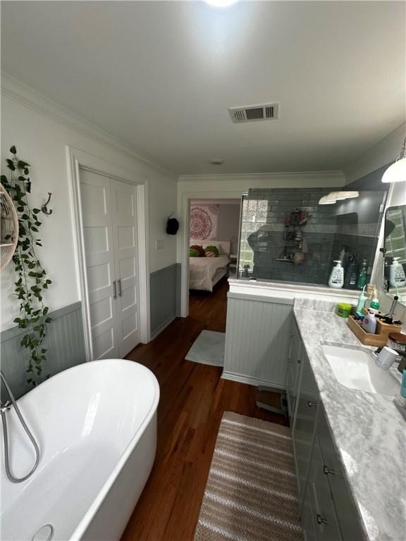 306 Timber St, College Station, TX 77840 - bathroom with vanity, wood finished floors, wainscoting, a freestanding bath, and crown molding