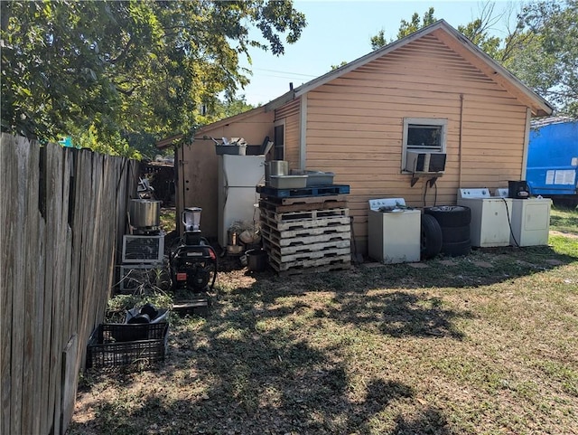 view of side of home featuring washer and clothes dryer and a yard