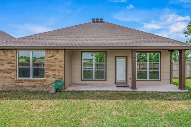 back of property featuring fence, a shingled roof, and a patio area