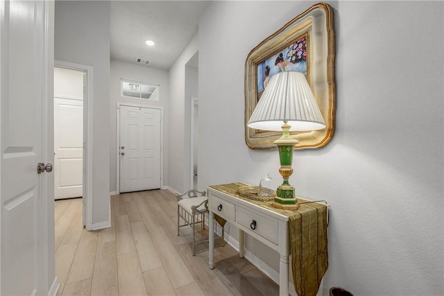 hallway with visible vents, recessed lighting, light wood-style flooring, and baseboards