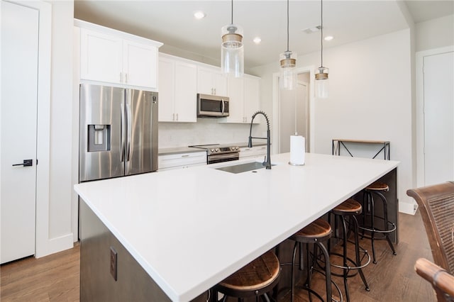 293 Estates Cir, College Station, TX 77840 - kitchen featuring appliances with stainless steel finishes, a sink, a large island with sink, wood finished floors, and recessed lighting