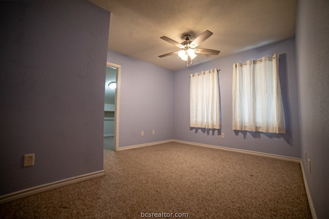 spare room featuring ceiling fan and carpet floors