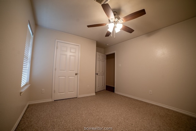 unfurnished bedroom with ceiling fan and carpet