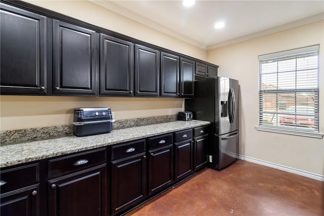 kitchen with ornamental molding, light stone countertops, and stainless steel fridge