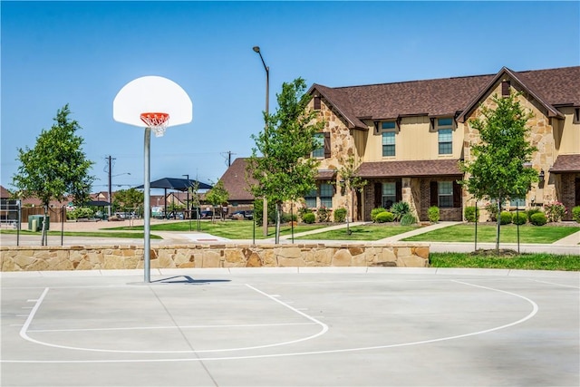 view of sport court featuring a lawn