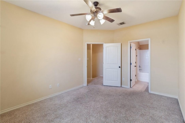 unfurnished bedroom with ceiling fan, light colored carpet, and connected bathroom