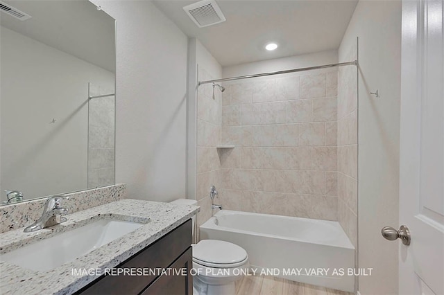 full bathroom featuring toilet, vanity, and tiled shower / bath