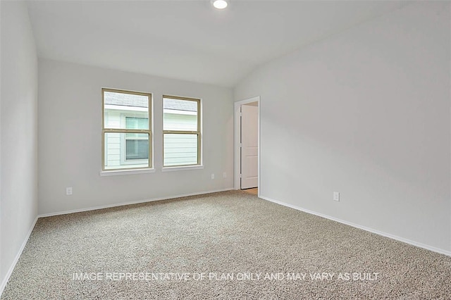 carpeted empty room featuring lofted ceiling