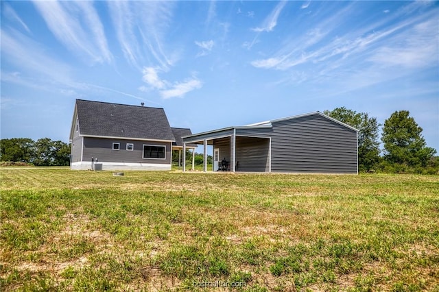 back of property featuring an outdoor structure and a lawn