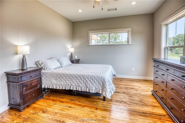 bedroom featuring light hardwood / wood-style flooring and multiple windows