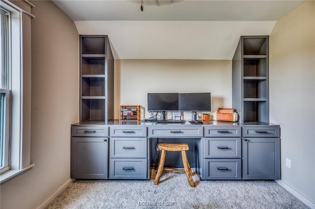 unfurnished office featuring light colored carpet and lofted ceiling