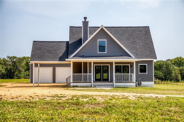 view of front of house featuring covered porch, a garage, and a front lawn